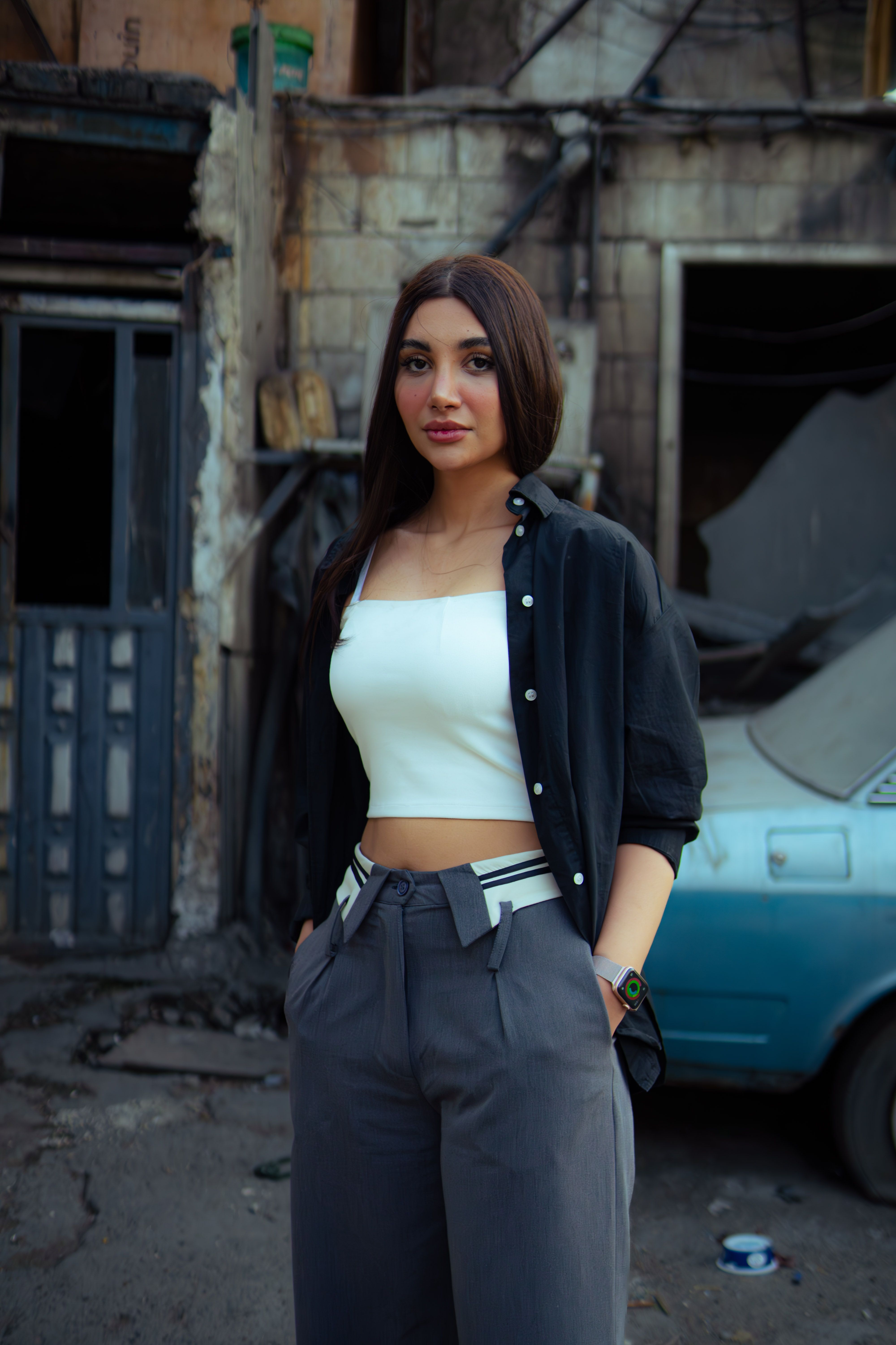Fashionable woman in a modern outfit standing against an urban backdrop in Tehran, Iran.