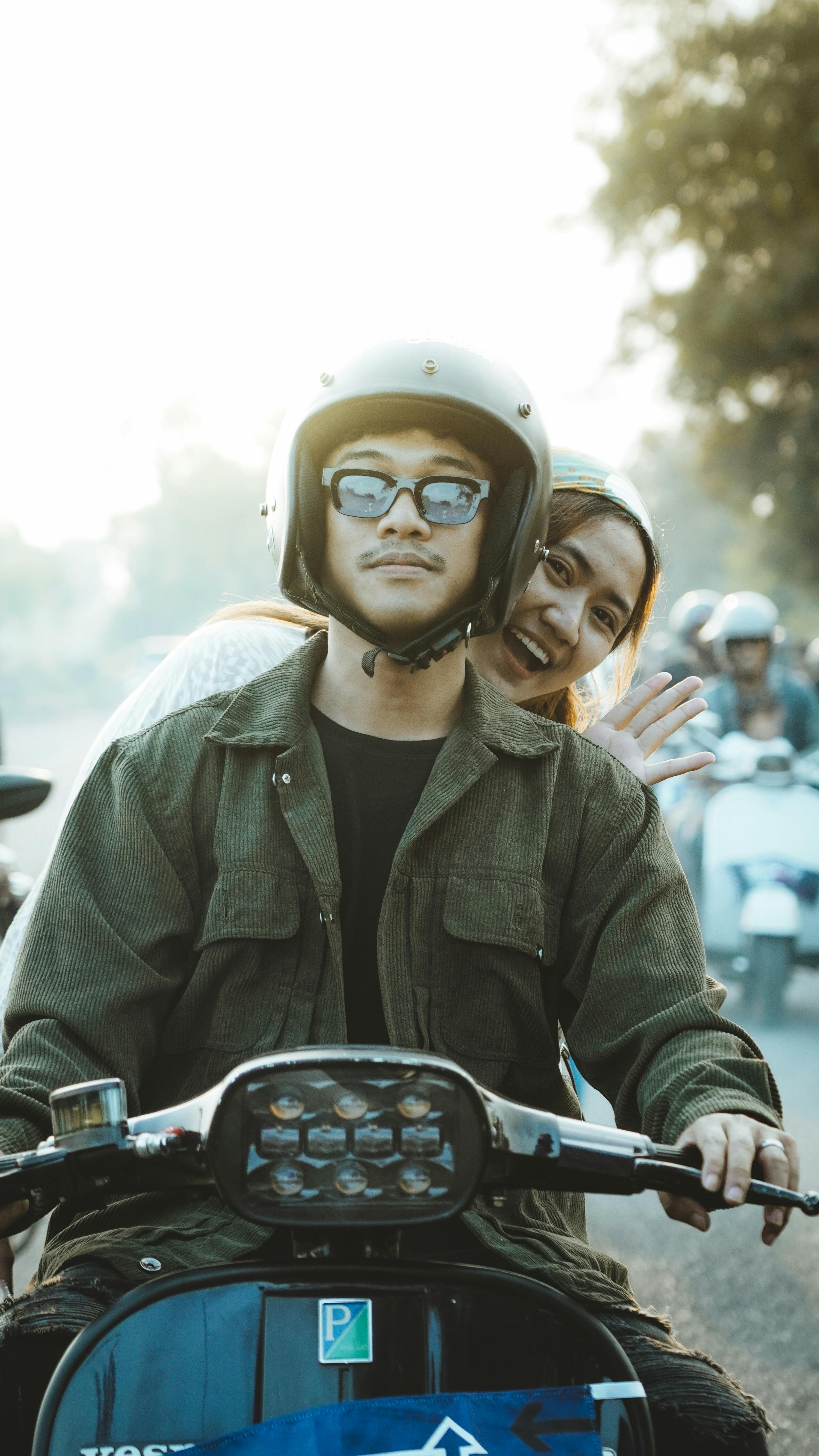 Free Friends enjoying a Vespa ride during a sunny day in East Java, Indonesia. Stock Photo