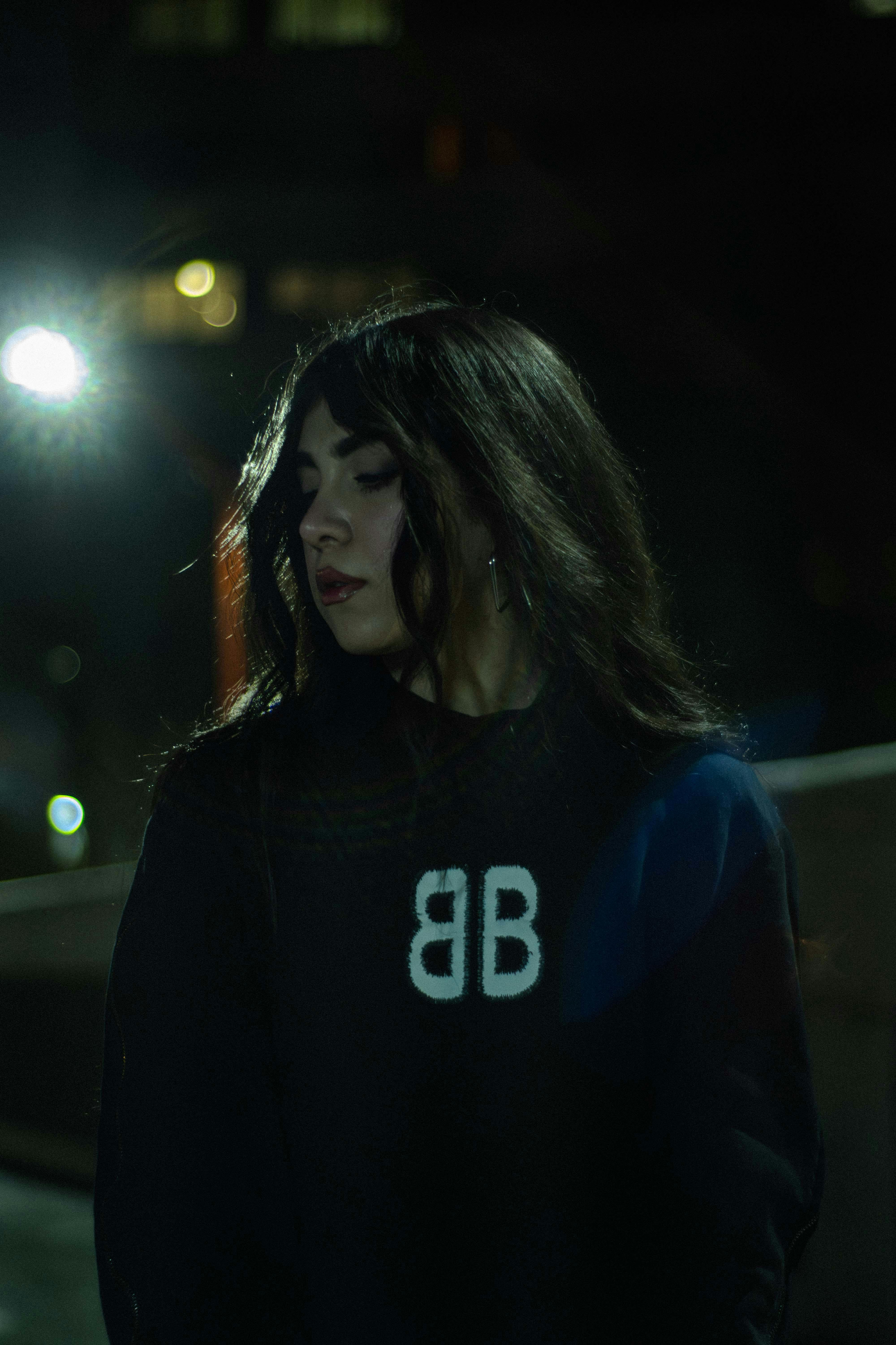 Enigmatic night portrait of a woman with long hair in Tehran's urban setting.