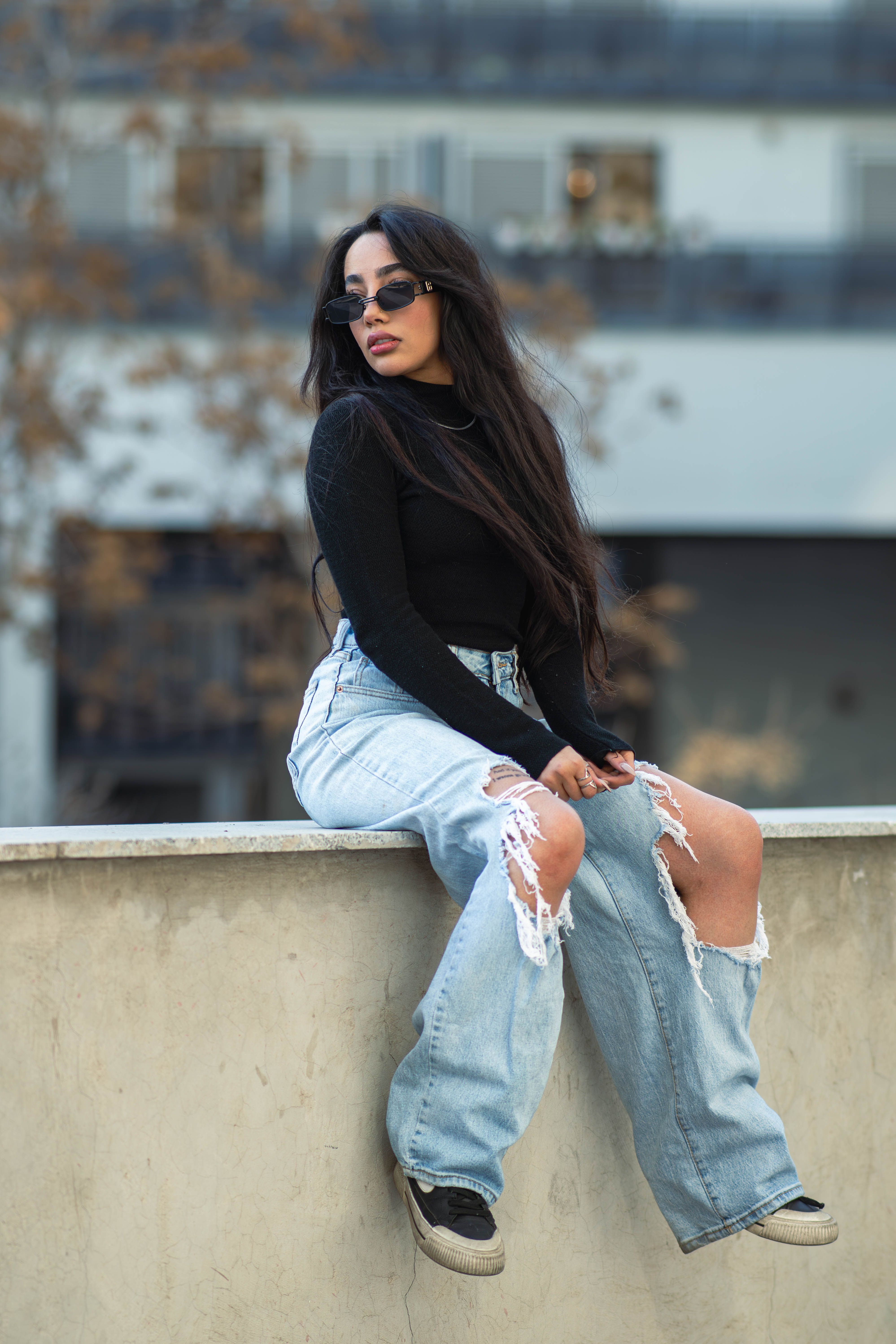 Woman in ripped jeans in city setting