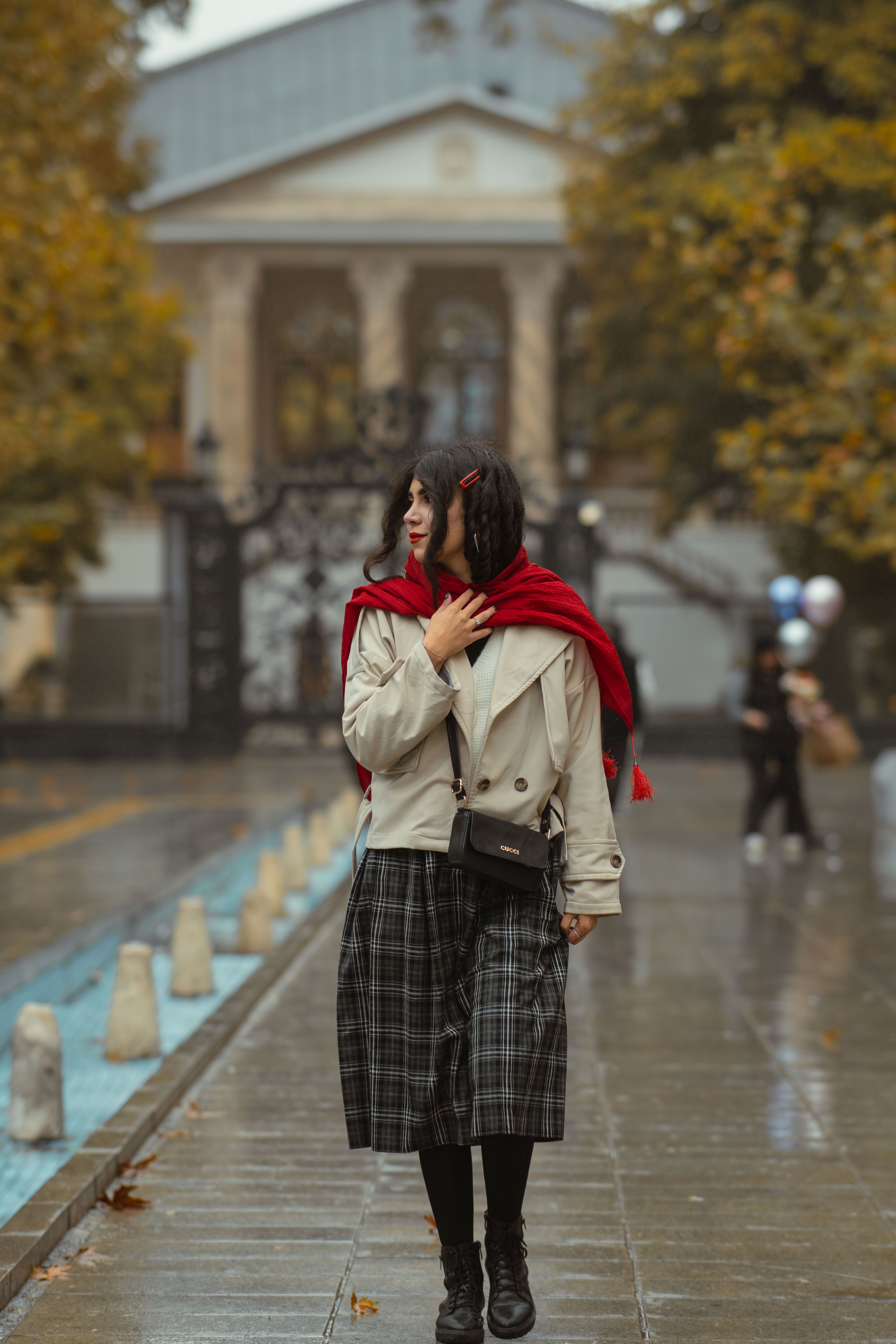 Woman styling plaid skirt on city street