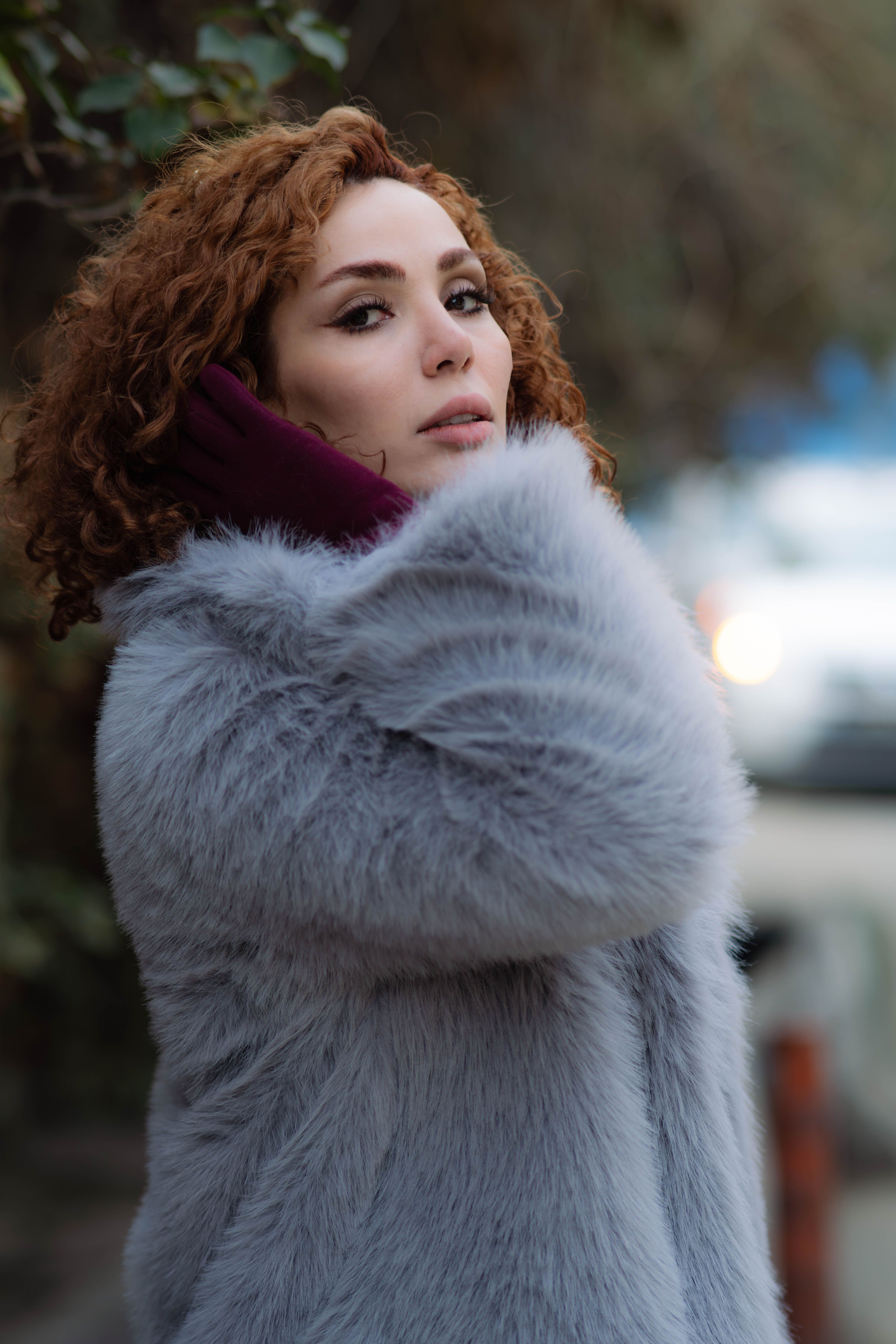 Stylish woman in fur coat on a Tehran street, embracing winter fashion.