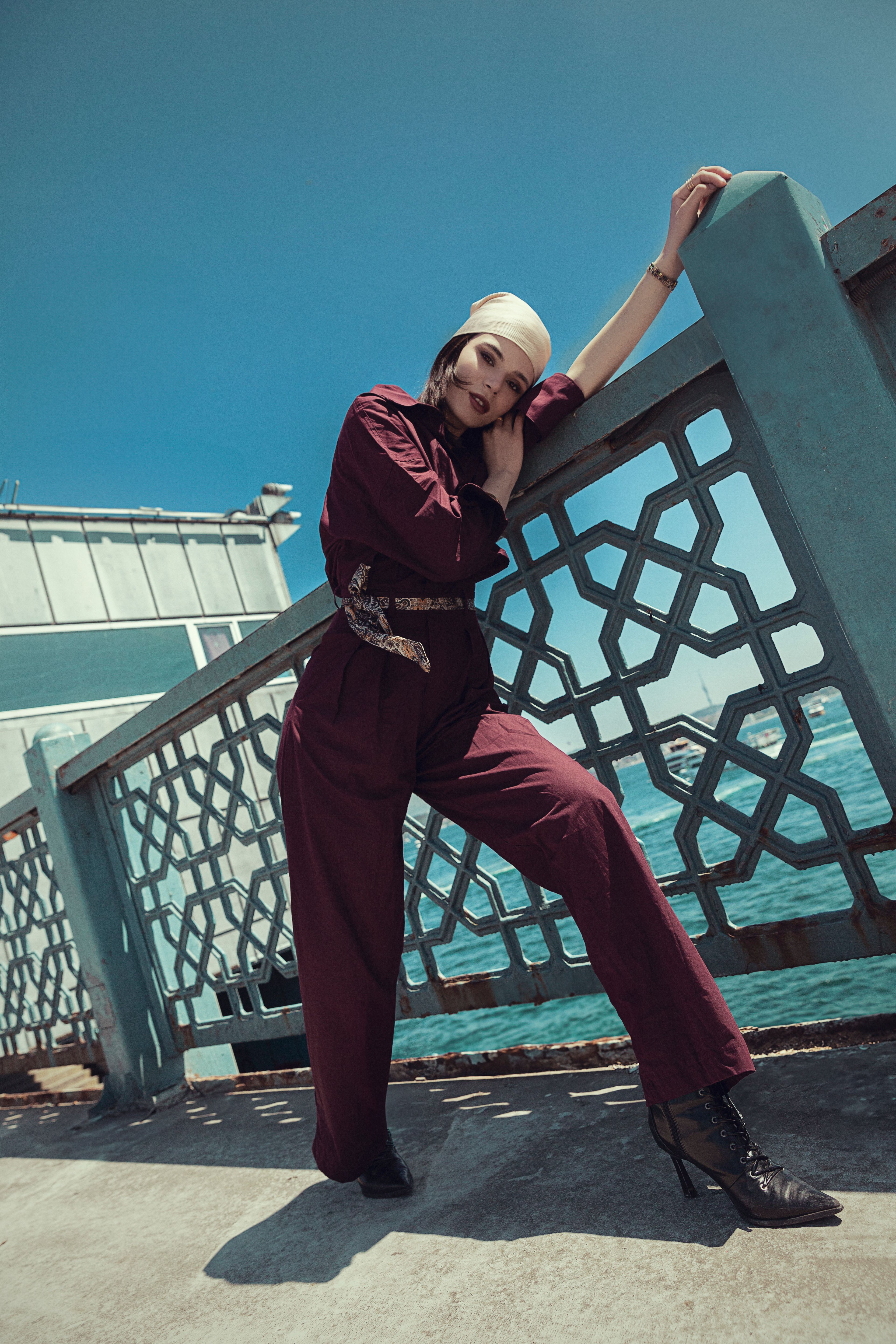 Stylish female model posing outdoors by İstanbul waterfront in a fashion shoot.