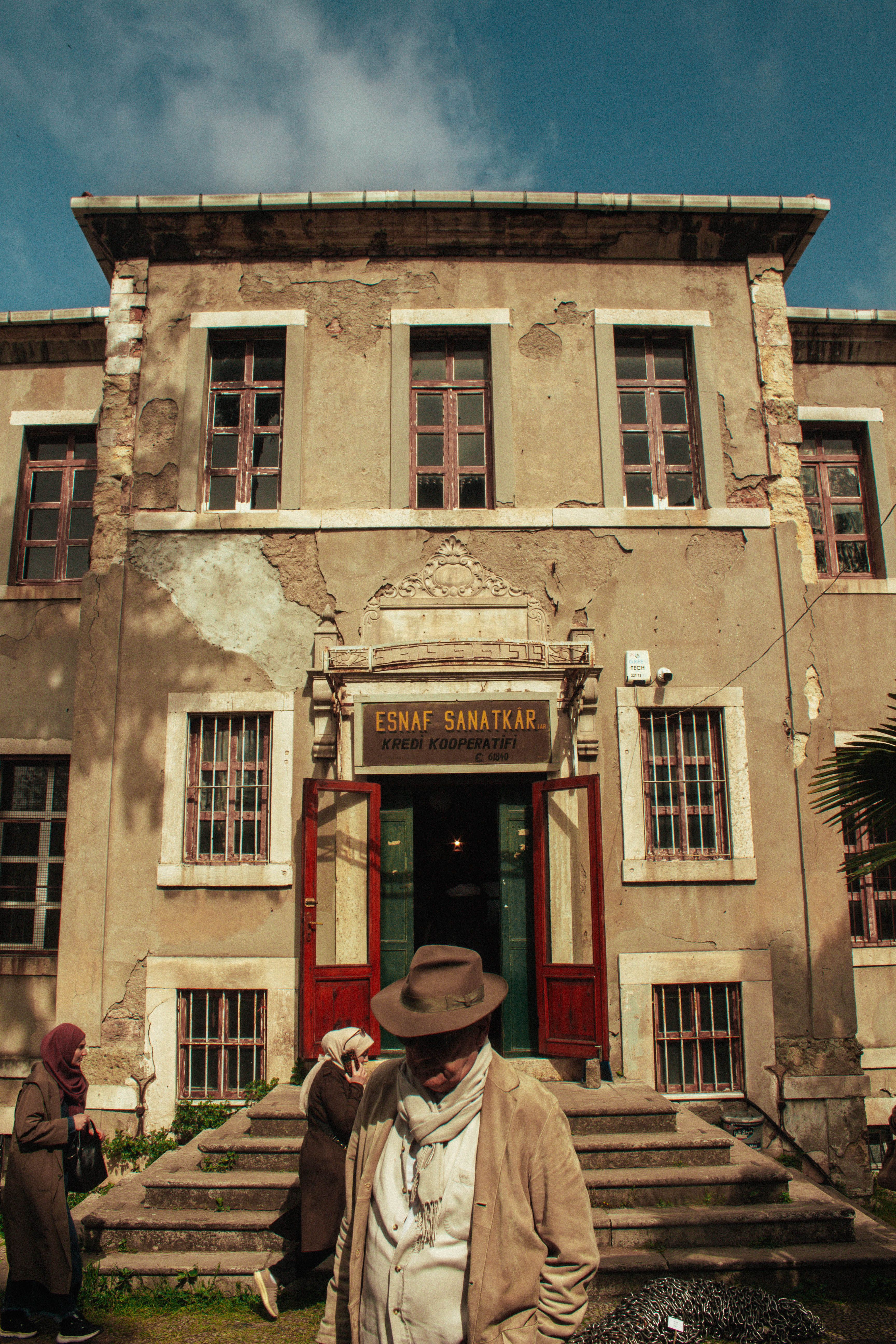 Vintage building facade in Istanbul with people in winter attire, showcasing urban history.