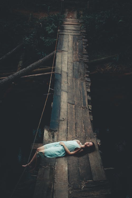 木製の橋の上に横たわる女性