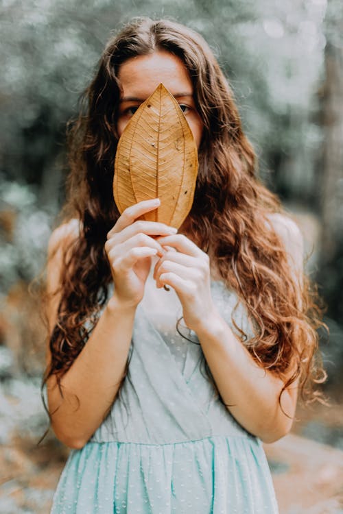 Free Woman Covering Her Face With A Brown Leaf Stock Photo