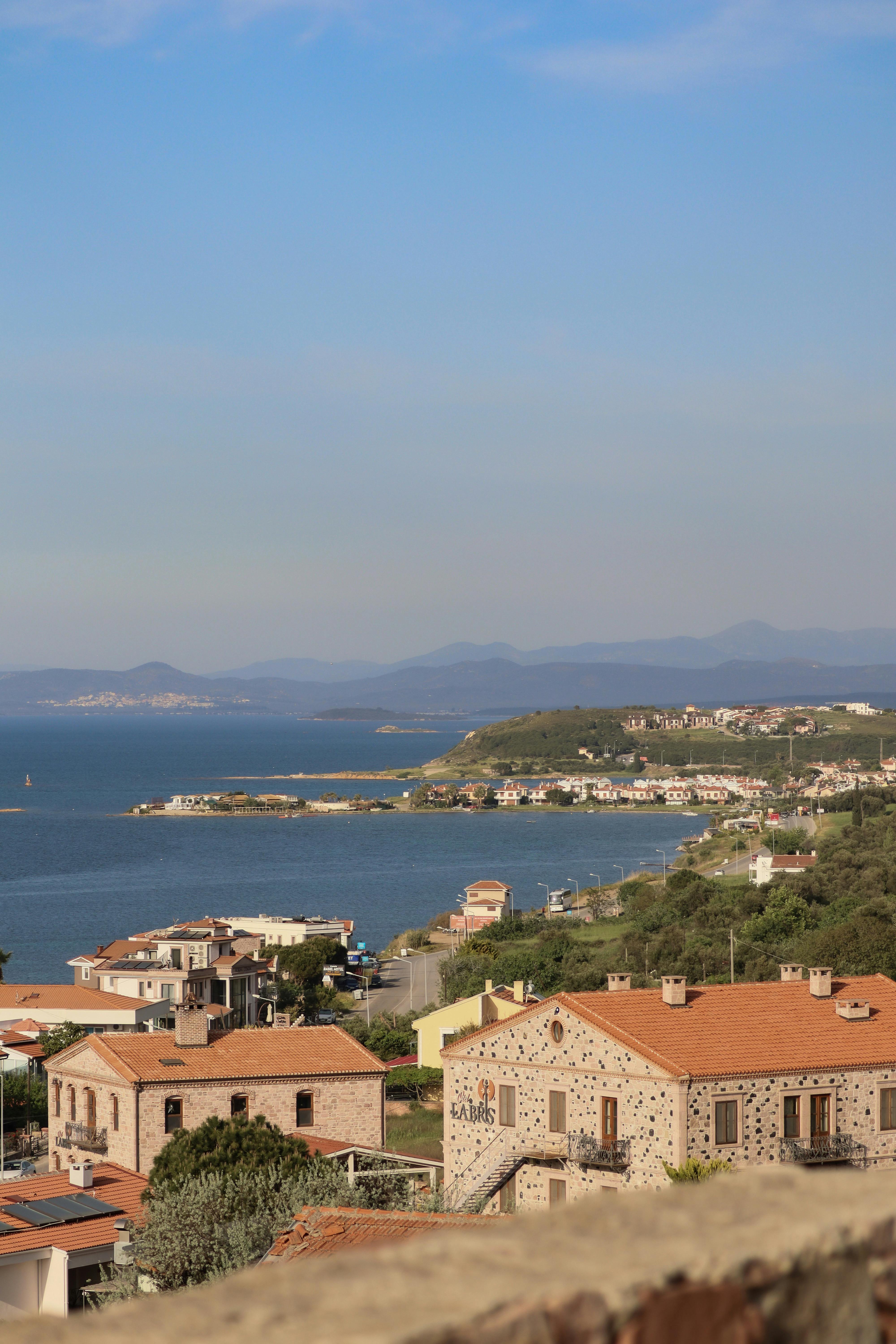 Charming coastal view featuring Italian village buildings, sea, and distant mountains.