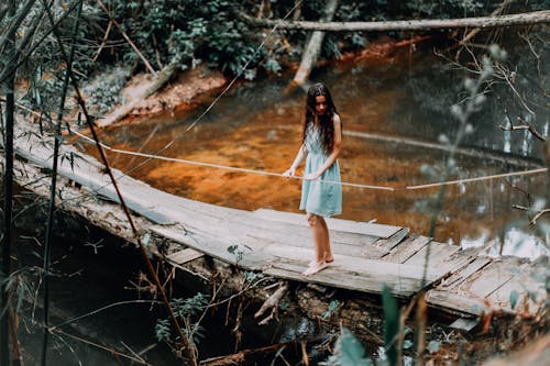 Free Woman Standing on Wooden Bridge Stock Photo