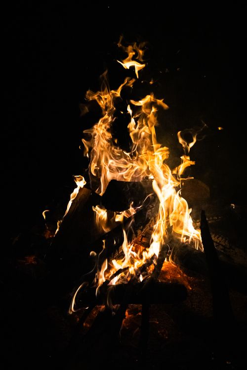 Free A captivating shot of a campfire's dancing flames against a dark night background. Stock Photo