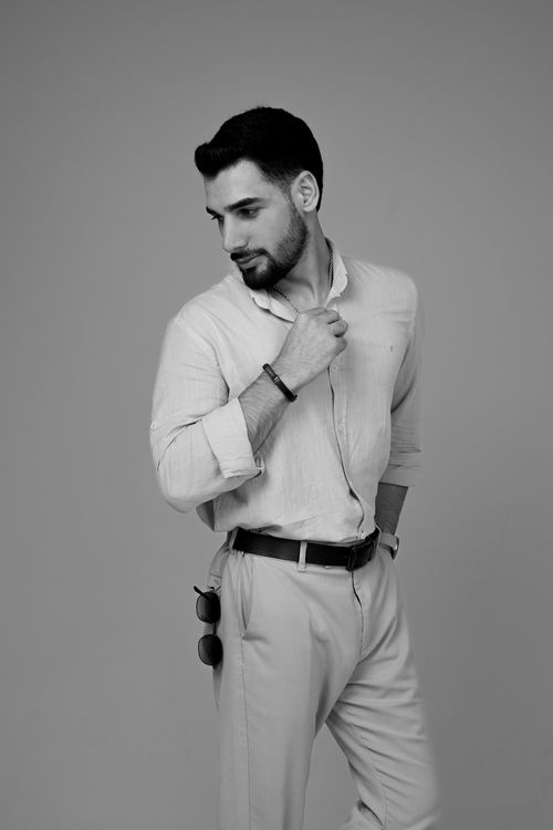 Free Monochrome photo of a fashionable man in a stylish pose, exuding modern elegance. Stock Photo