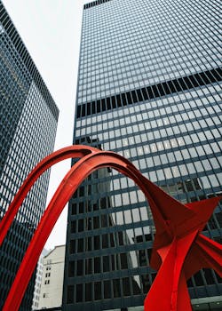 Striking red sculpture contrasts with tall glass skyscrapers in Chicago, Illinois.
