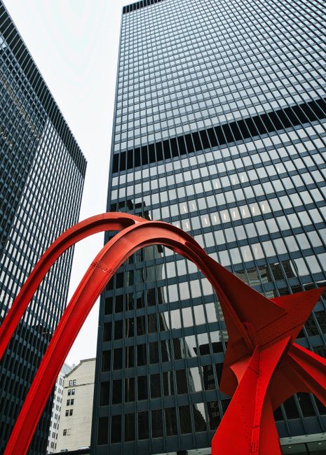 Striking red sculpture contrasts with tall glass skyscrapers in Chicago, Illinois.