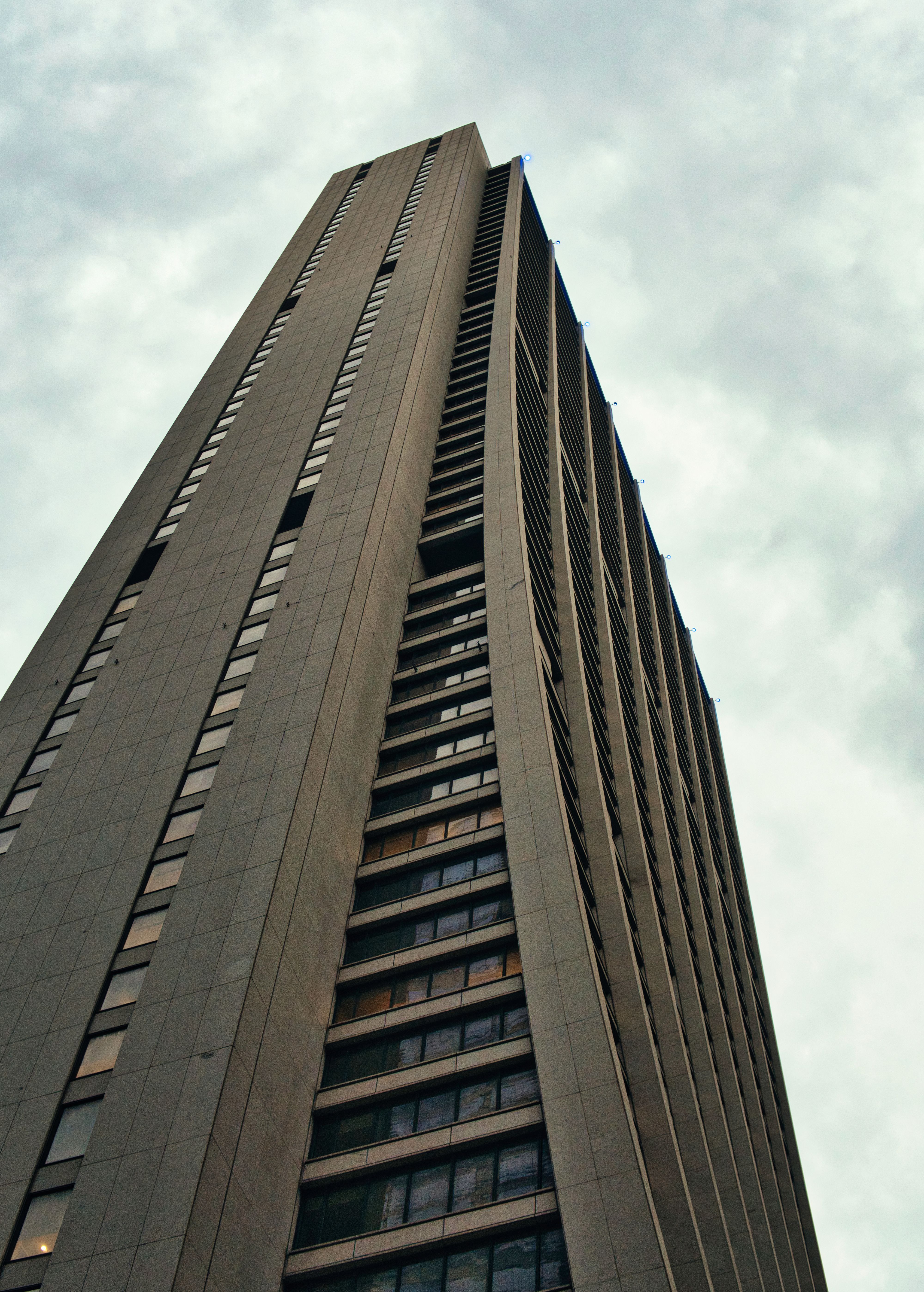 Kostenlos Ein moderner Wolkenkratzer ragt in den bewölkten Himmel und fängt die architektonische Essenz Chicagos ein. Stock-Foto