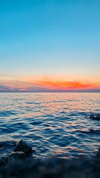 Breathtaking view of a tranquil ocean sunset with vibrant sky hues, perfect for relaxation themes.