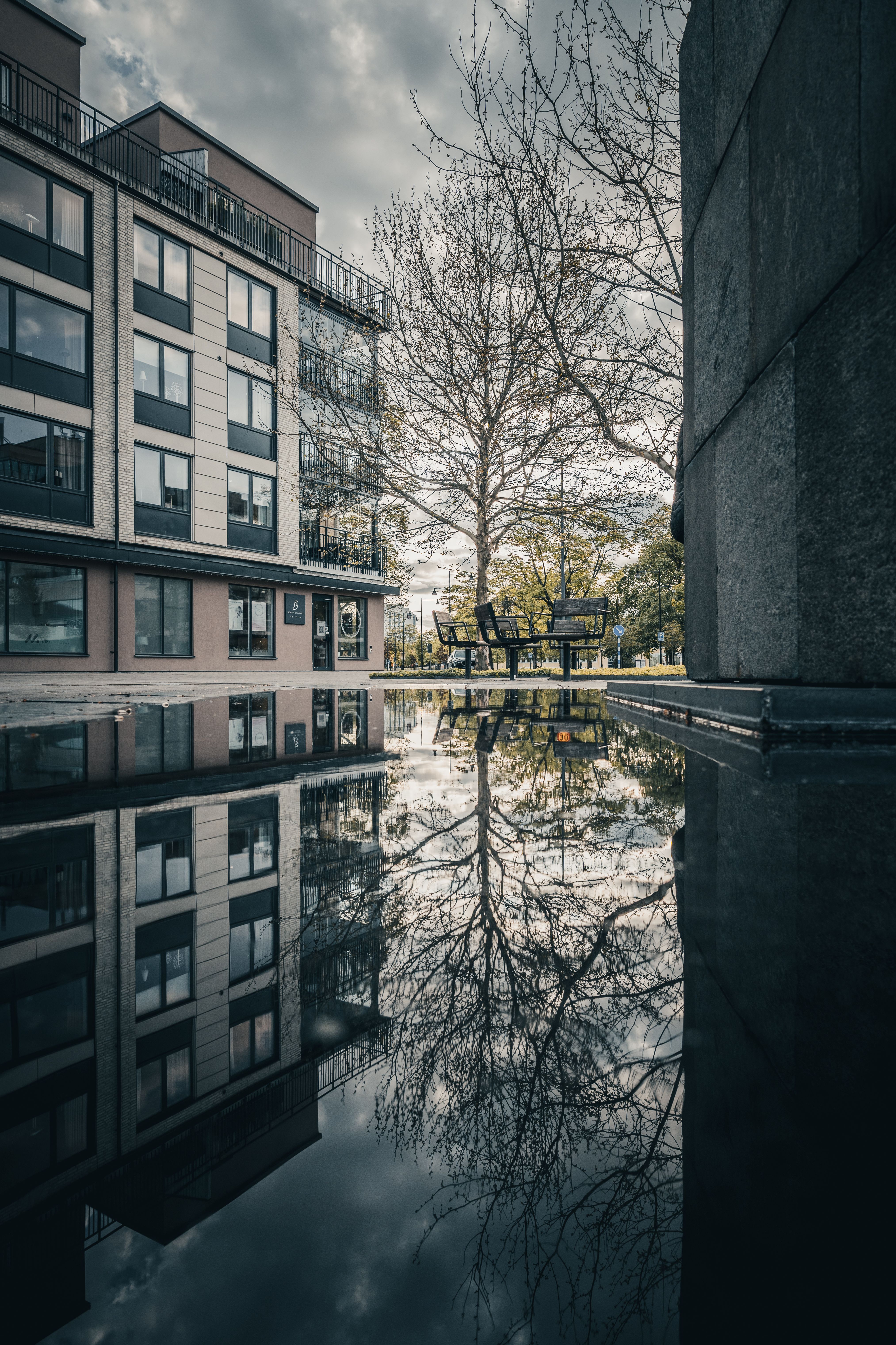 Serene Urban Reflection in a Puddle · Free Stock Photo