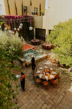 Charming outdoor wedding reception setup with elegant decor, lush greenery, and ambient lighting.