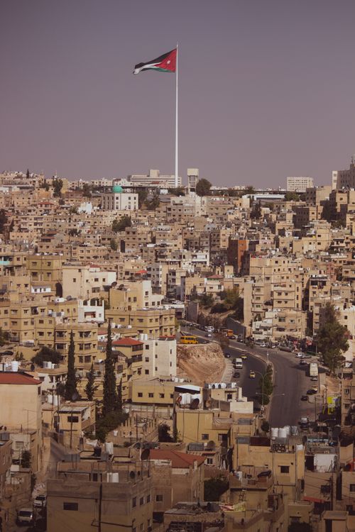 Free A view of Amman cityscape with the Jordanian flag prominently displayed. Stock Photo