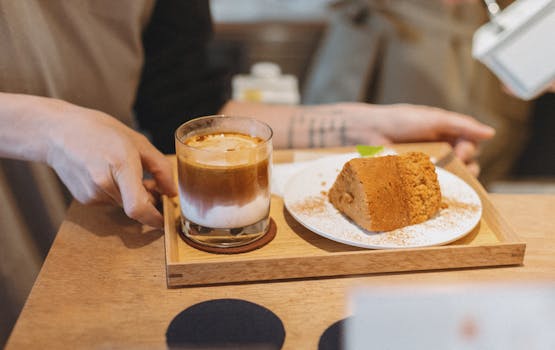 A barista serves a latte and dessert at a cozy café in Shinjuku, Tokyo, Japan.
