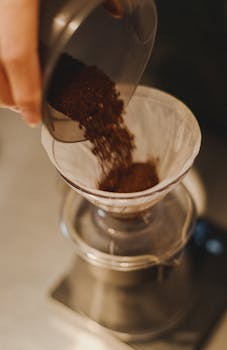 Detailed view of coffee grounds being poured for brewing in Tokyo coffee shop.