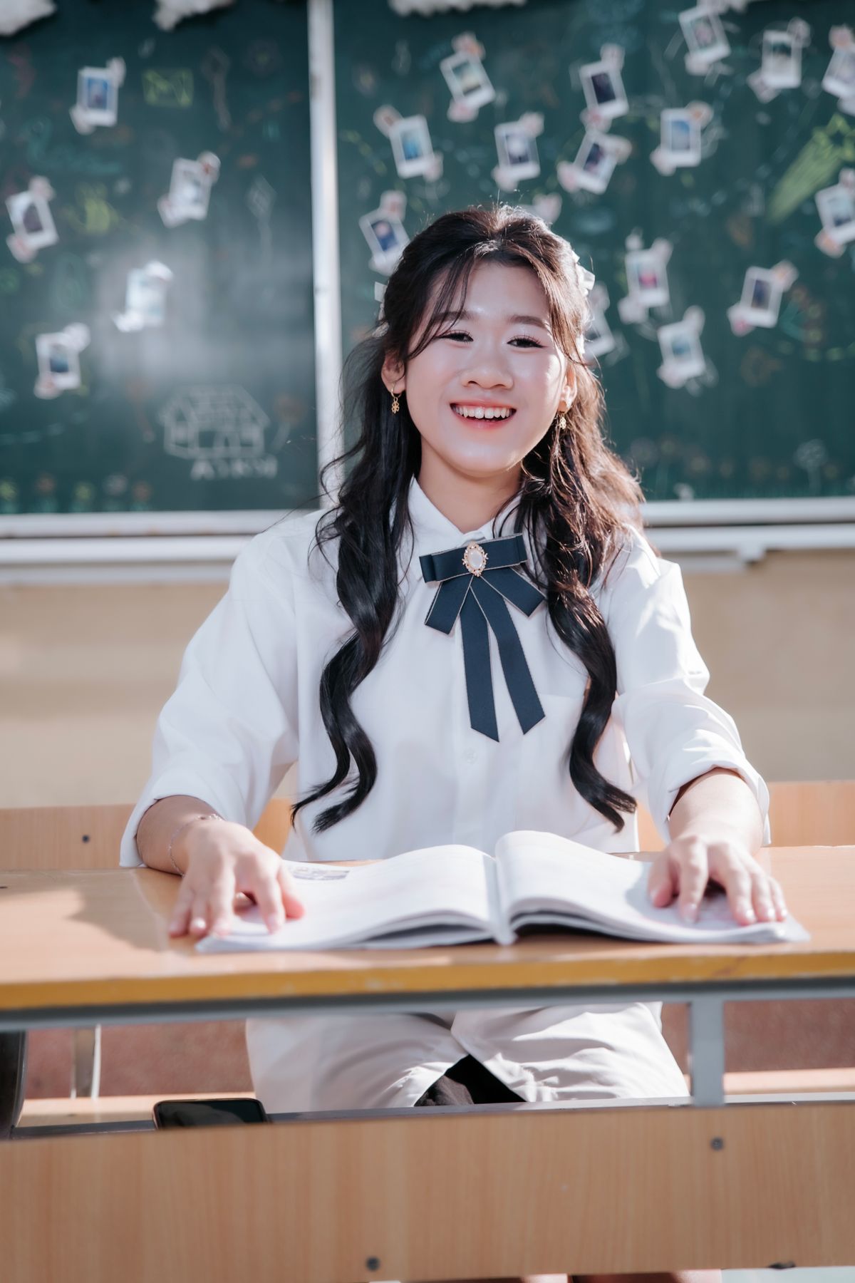 Happy student sitting at desk with open book ready to learn