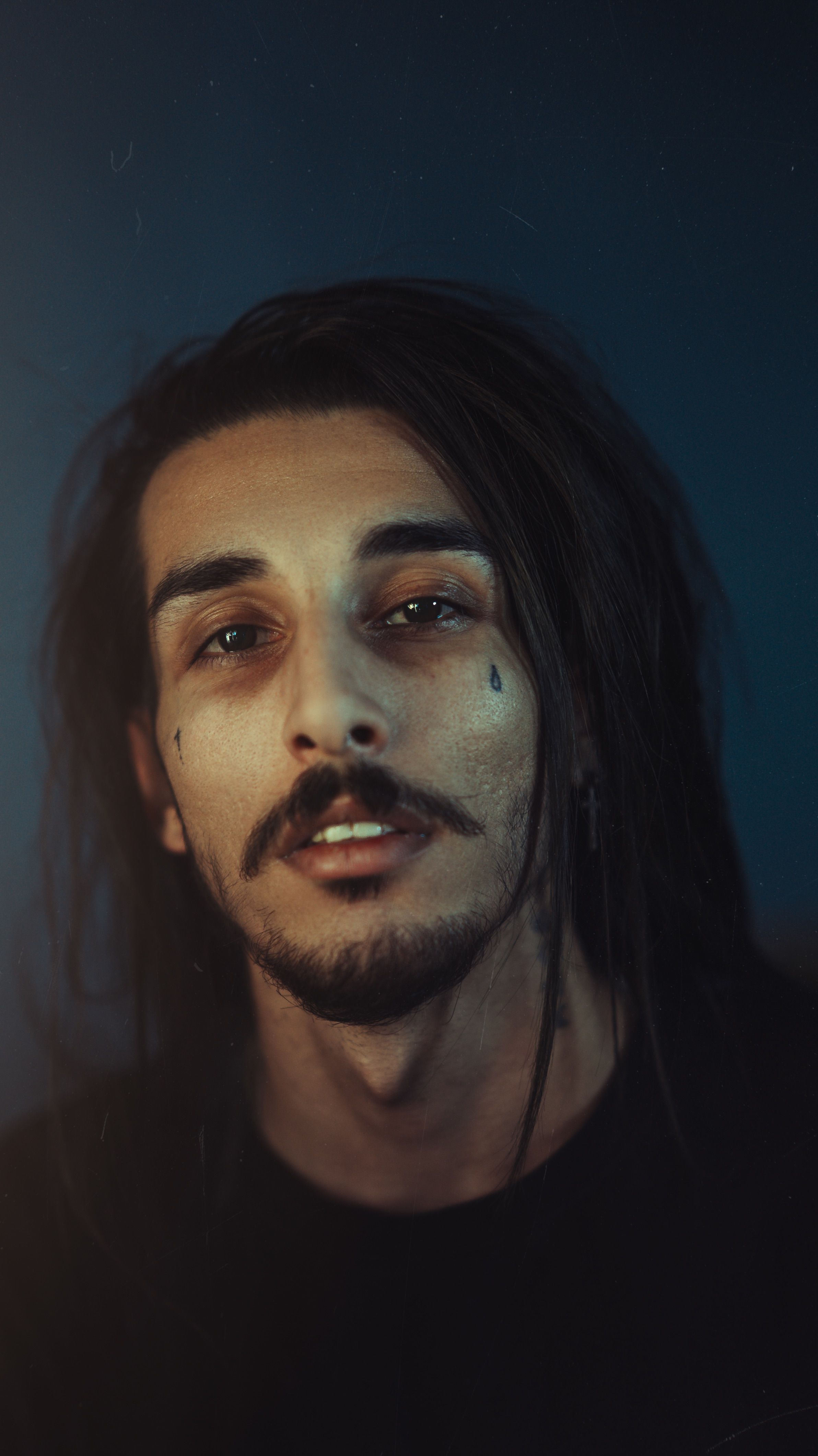 Moody Portrait of Man with Long Hair and Tattoos