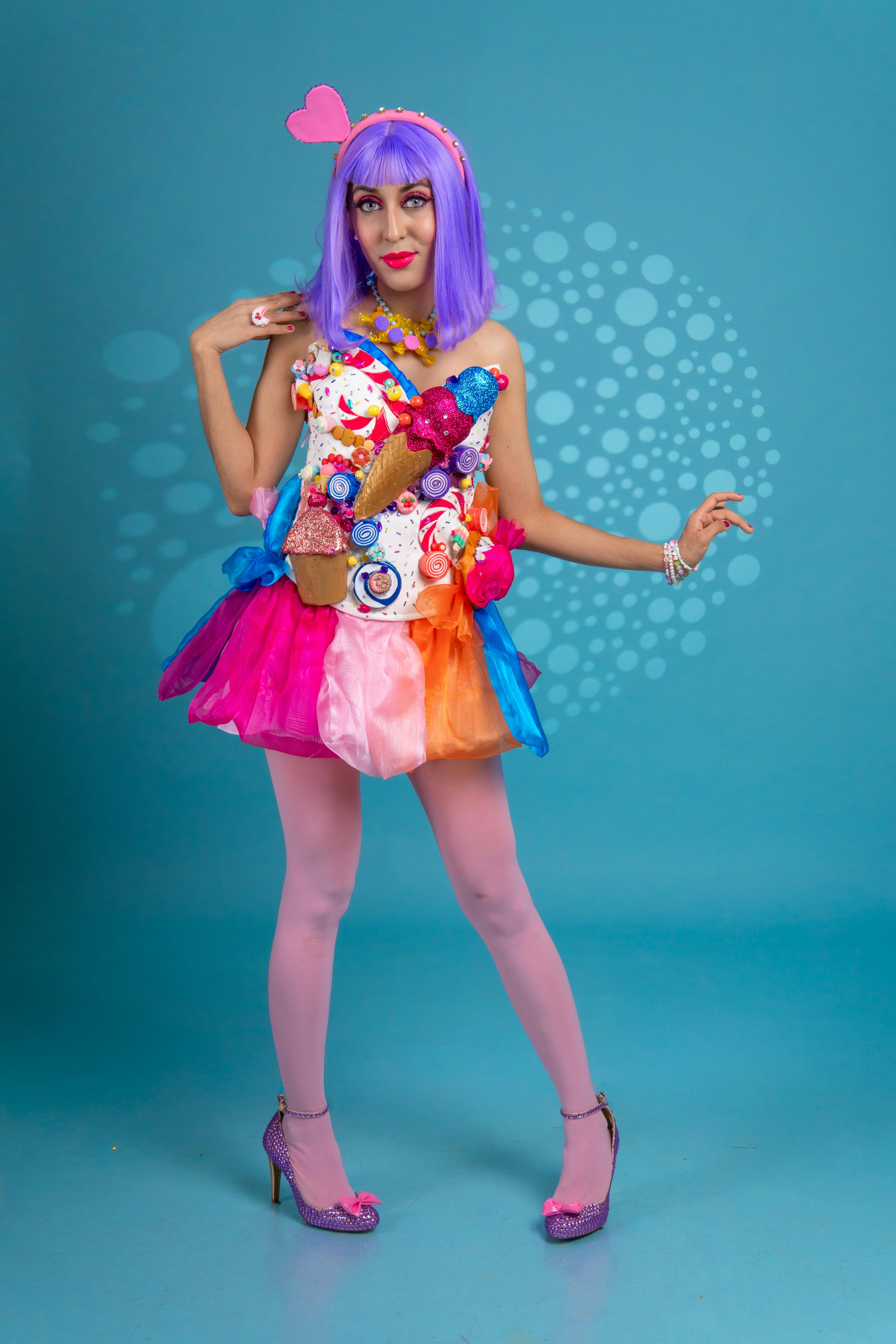 A vibrant costume featuring a purple wig, pink lips, and colorful accessories.