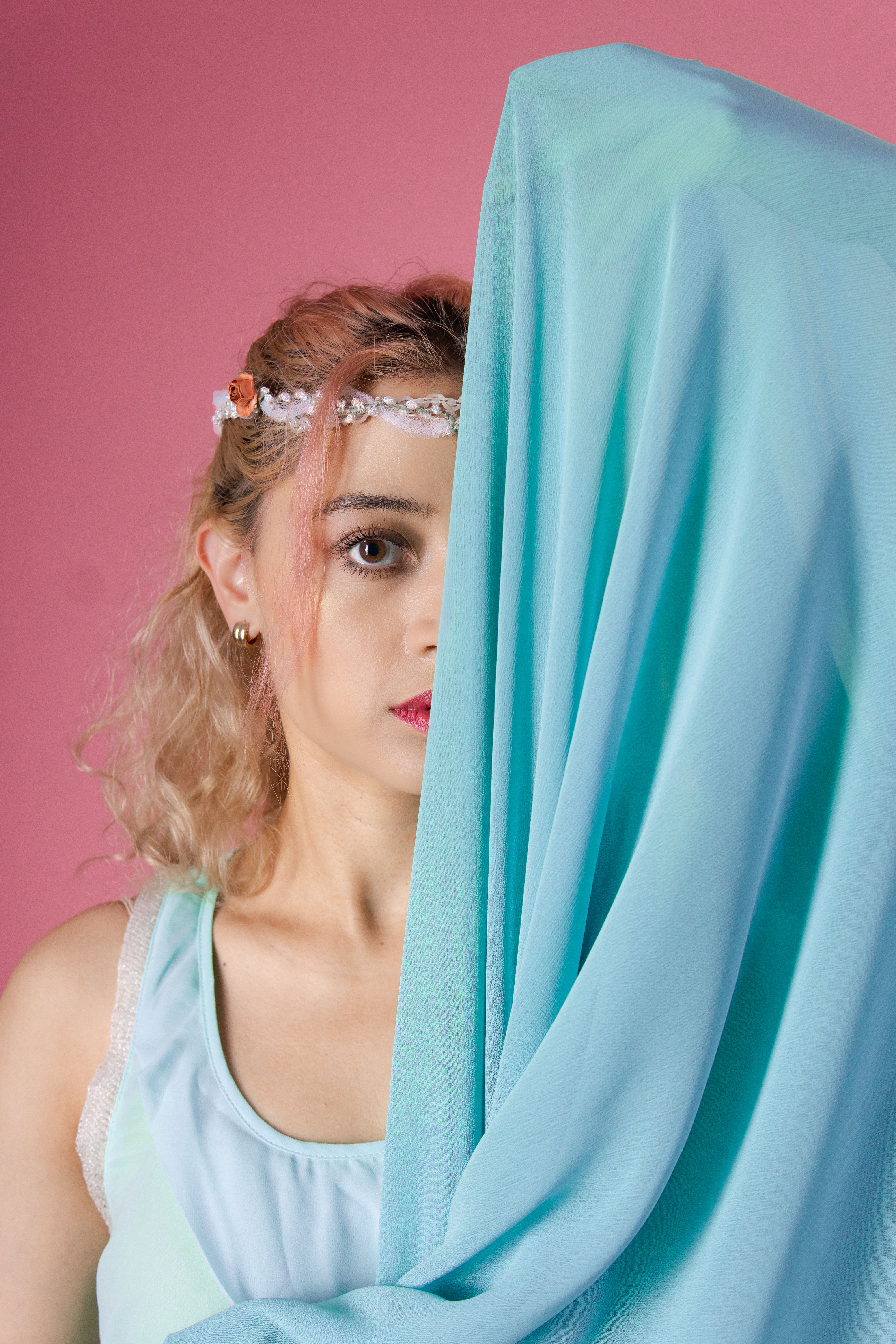 Elegant portrait of a female dancer with mint fabric against a pink backdrop.