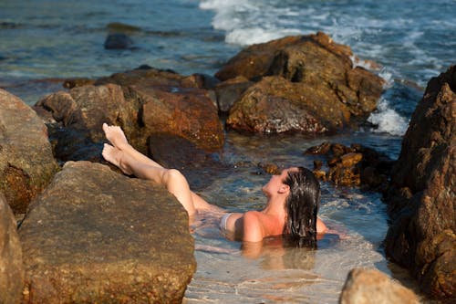 岩の横で泳ぐ女性