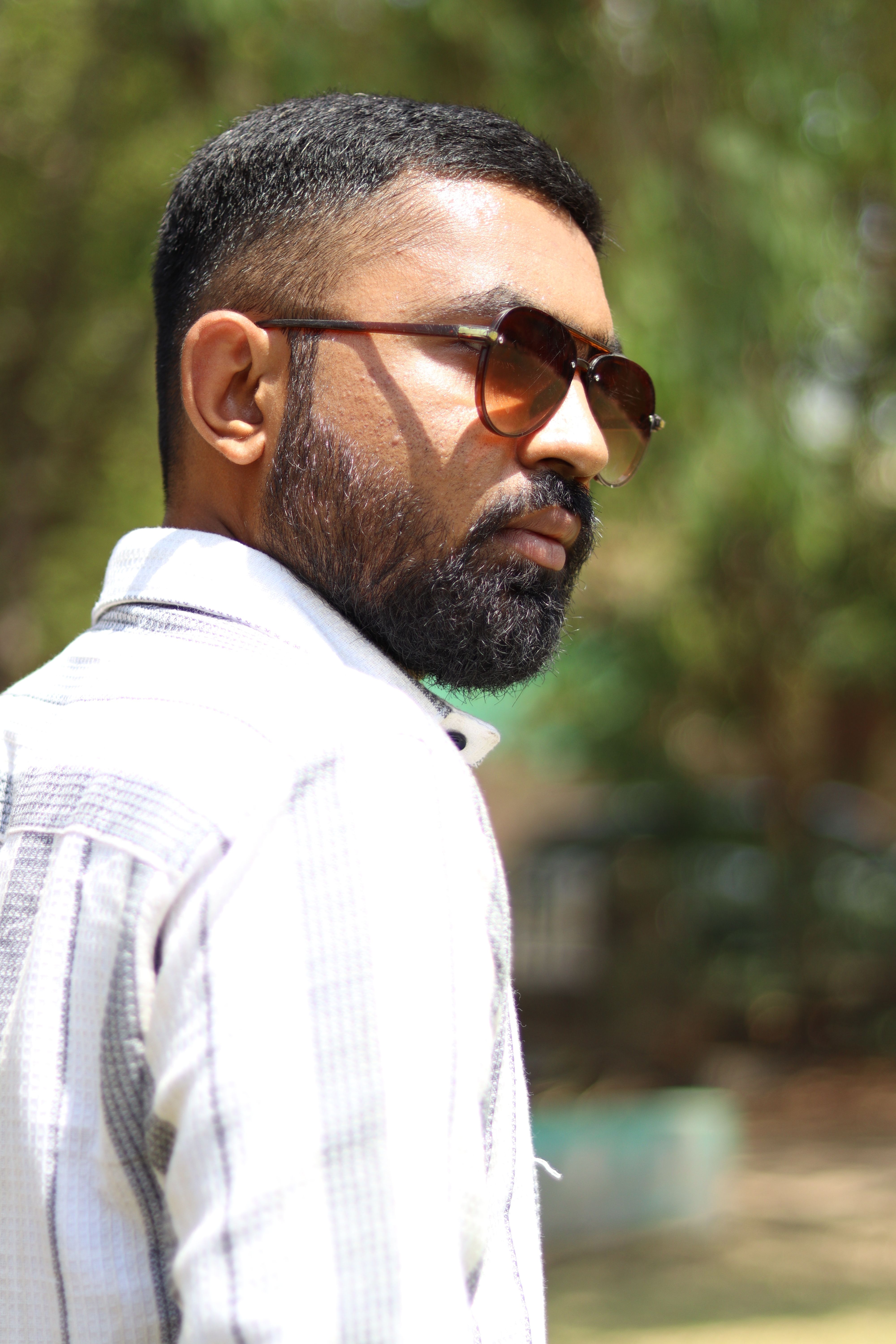 Portrait of a fashionable man wearing sunglasses outdoors in Ahmedabad.