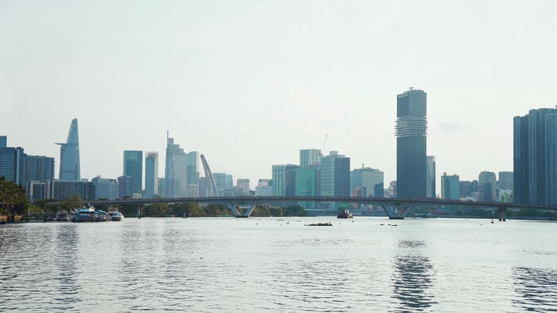 Ho Chi Minh City's skyline over the river, with a bridge in the foreground