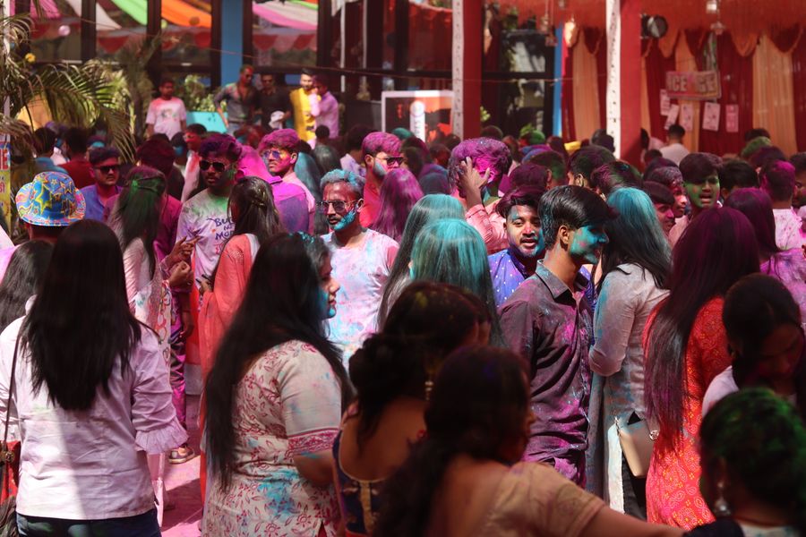 A lively scene of people celebrating Holi with colorful powders.