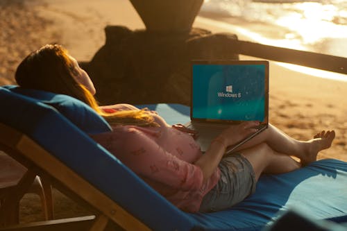 Vrouw Met Behulp Van Grijze Laptop Op Strand