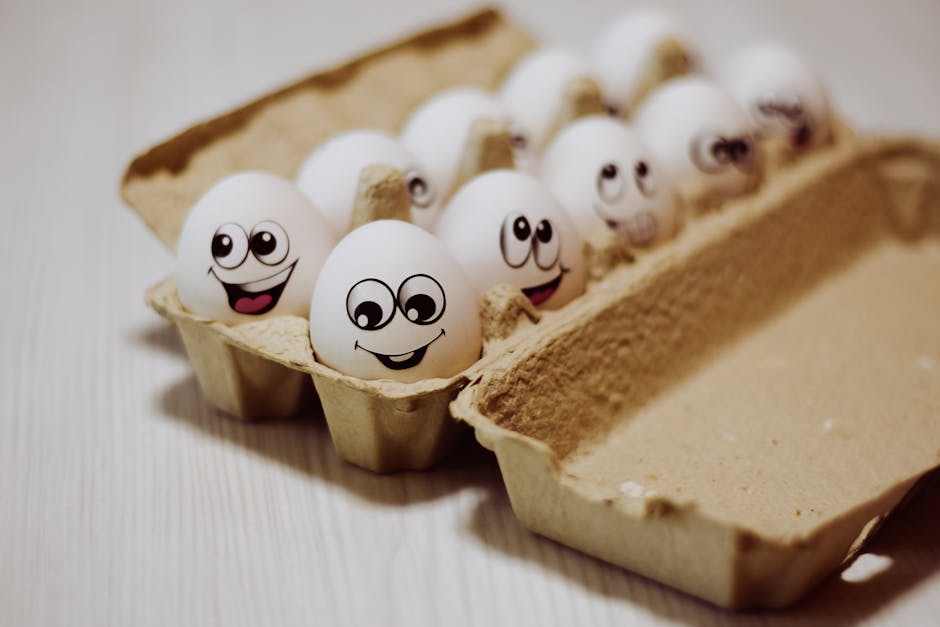 Carton of eggs with funny smiley faces drawn, providing a whimsical touch to food photography.