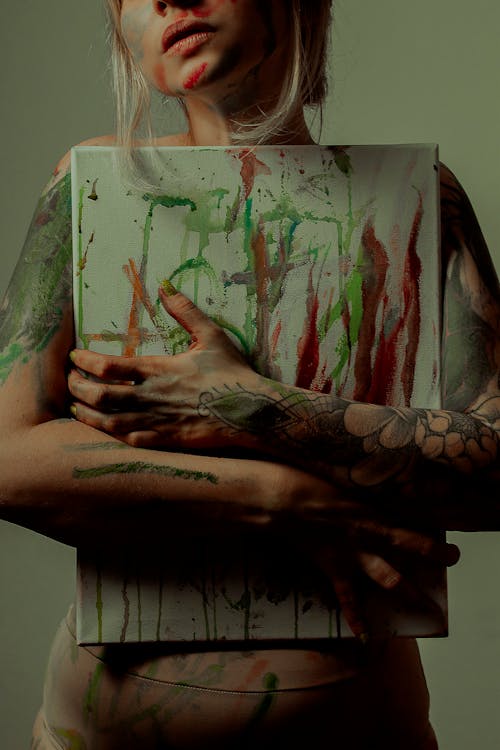 Фотография человека, держащего абстрактную картину