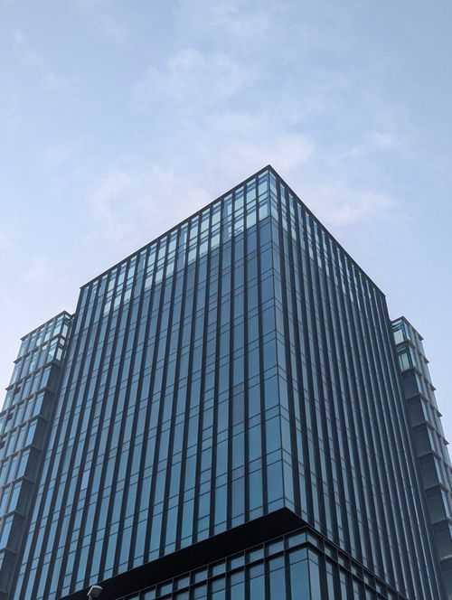 Free A towering glass skyscraper reaching into a clear blue sky, representing modern architecture. Stock Photo