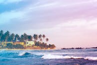 日落时分，斯里兰卡丹布拉的海滩宁静，棕榈树摇曳，海浪轻拍