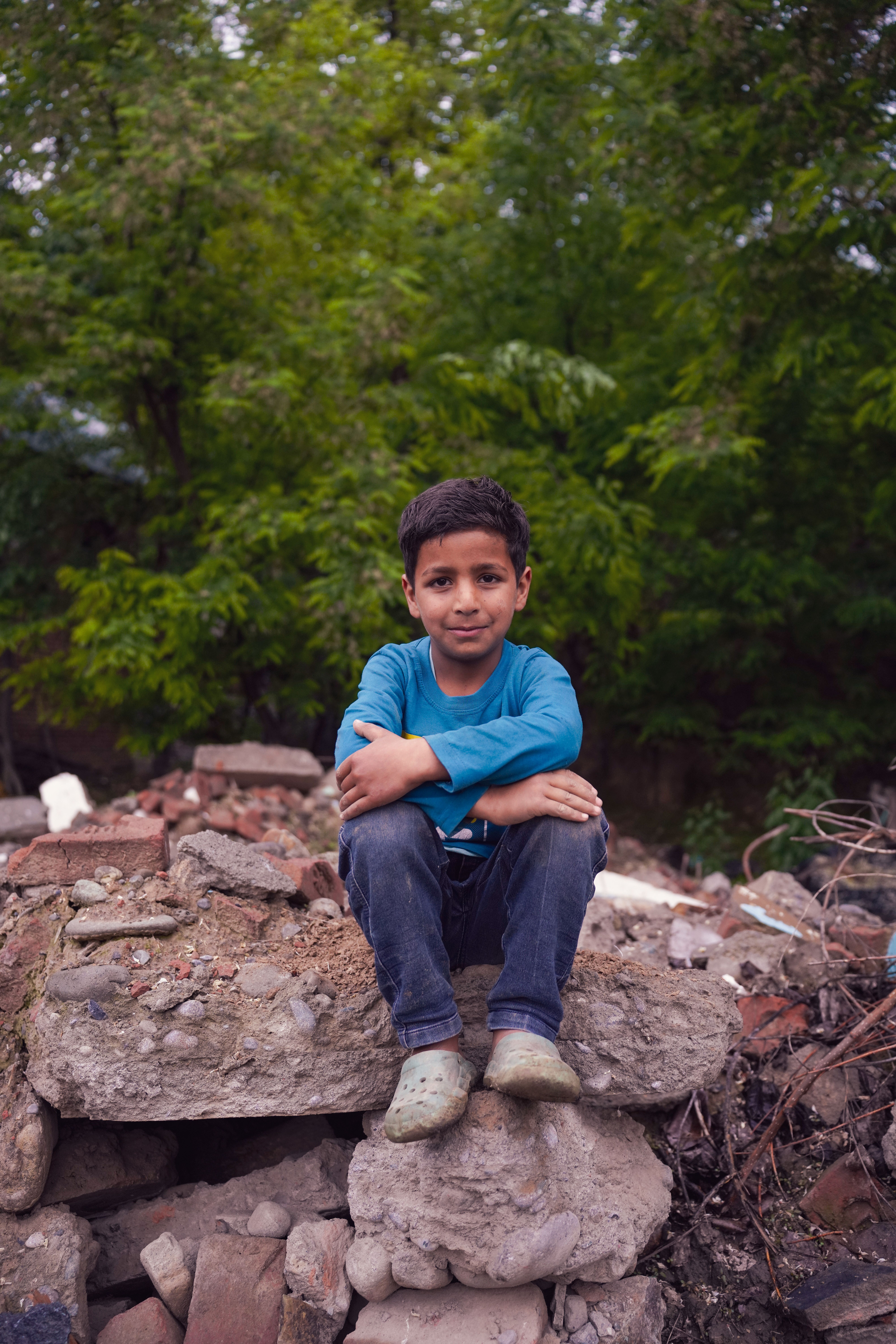 Portrait of a Young Boy Sitting Outdoors · Free Stock Photo