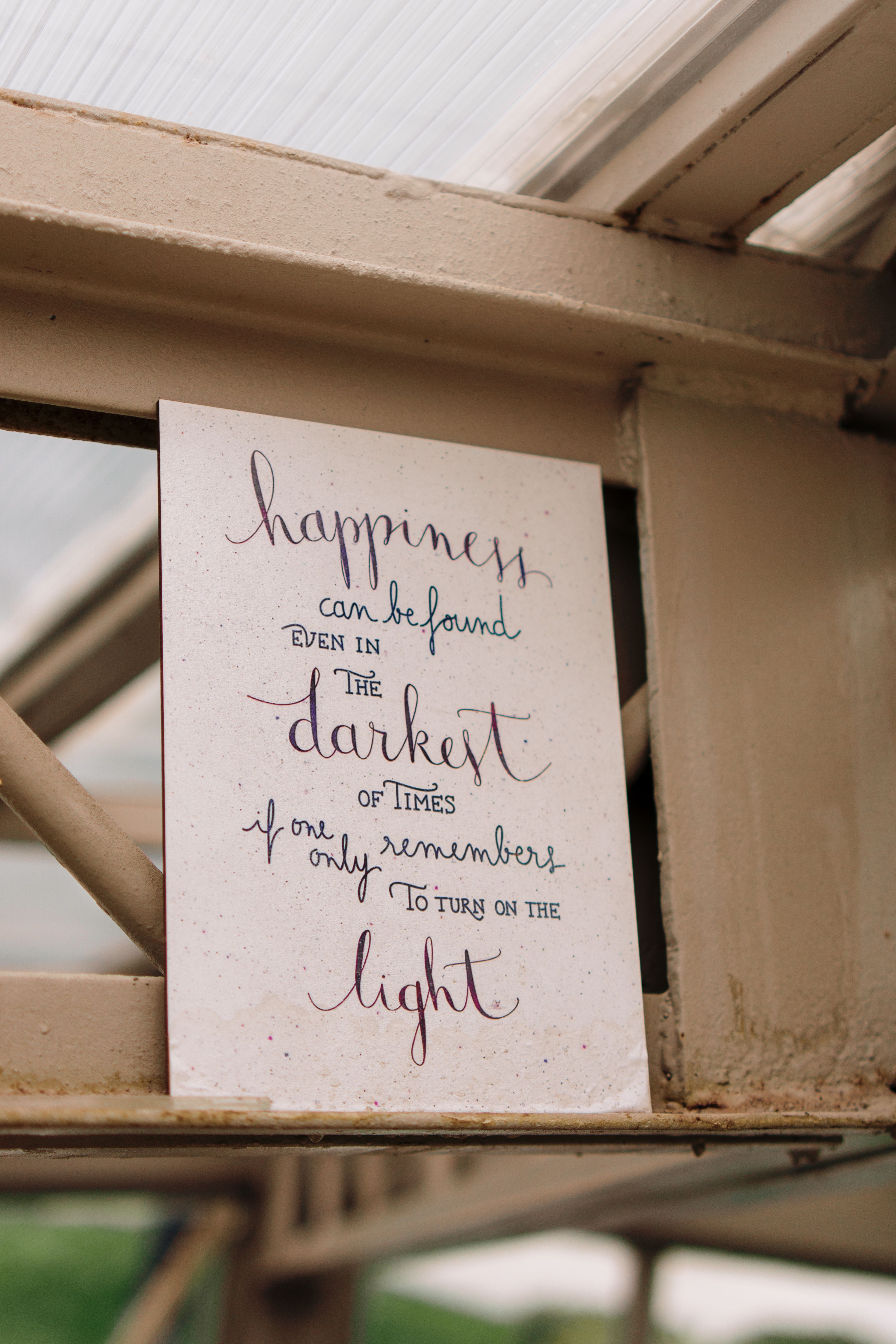 An inspirational quote poster displayed on a metal beam, conveying a positive message.