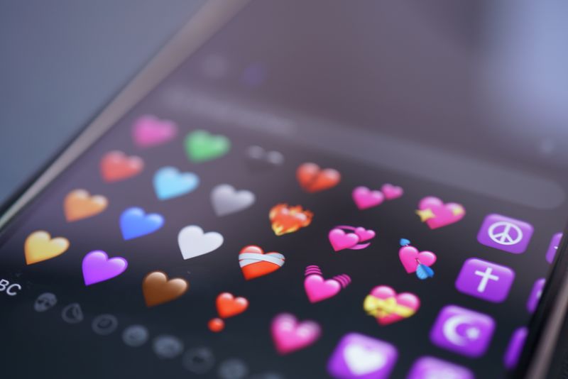 Close-up of colorful heart emojis displayed on a smartphone screen