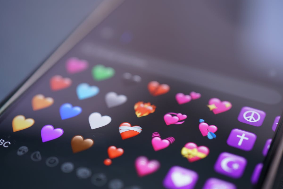 Schermo di smartphone con emoji a forma di cuore colorate ravvicinate