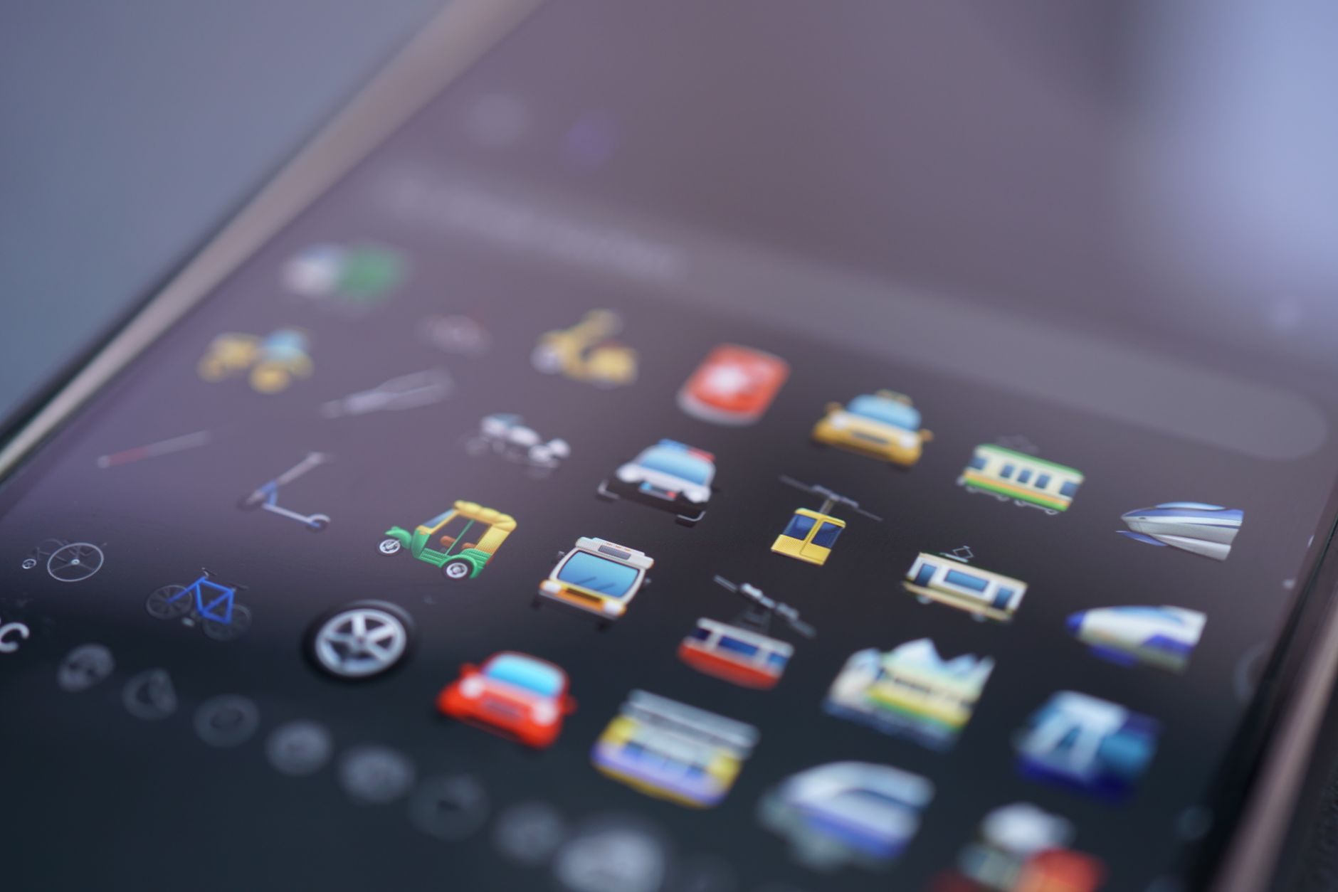 Vibrant close-up of various emojis on a smartphone screen representing digital communication.
