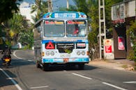 一辆充满活力的巴士沿着乌纳瓦图纳阳光明媚的街道行驶，捕捉着斯里兰卡的当地文化