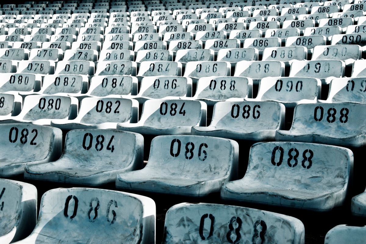 Rows of empty stadium seats, representing the typical no-show rate of free webinars
