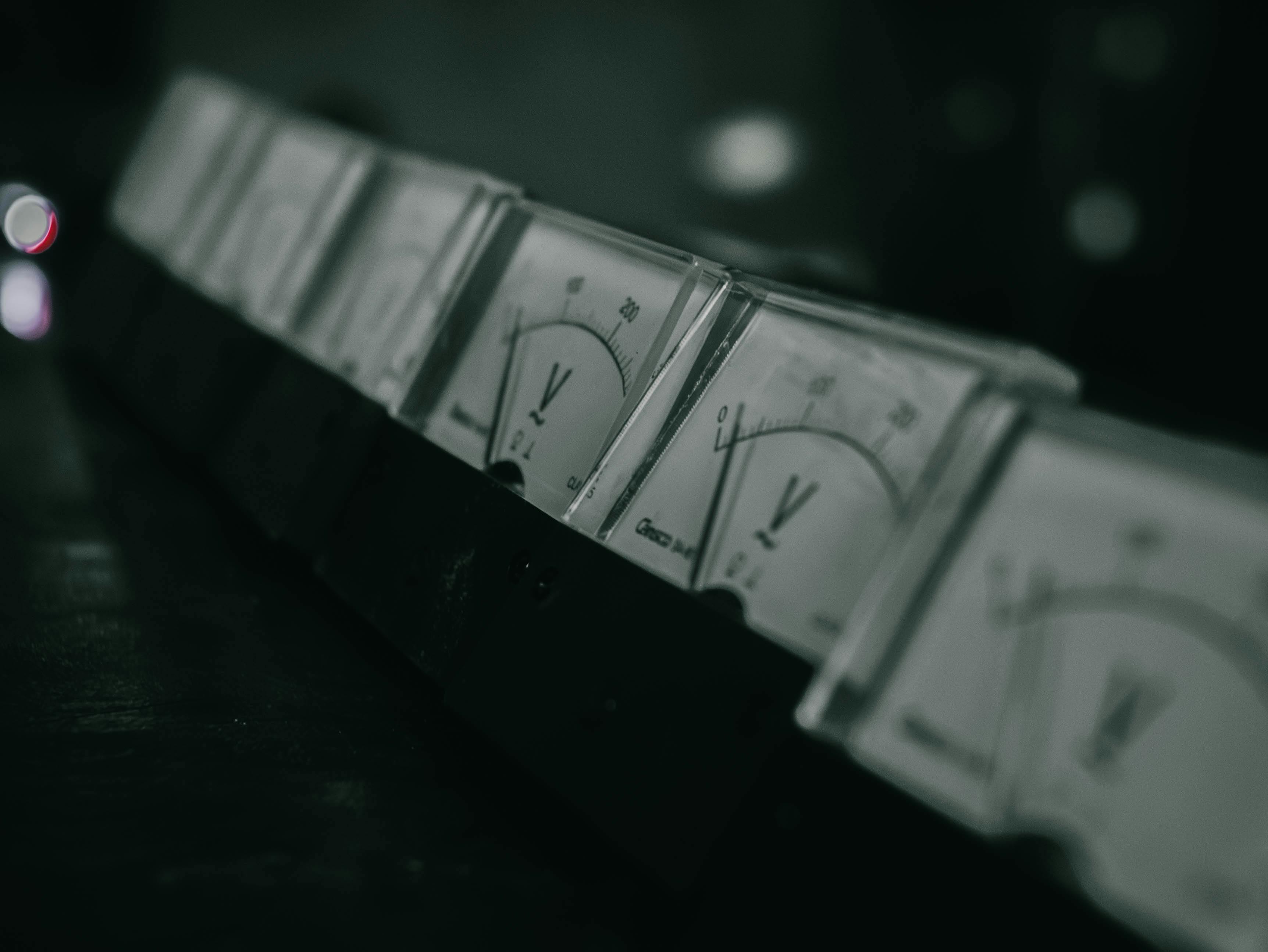 Free Close-up of vintage analog voltage meters in a dark industrial setting with a moody atmosphere. Stock Photo