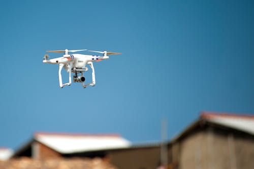 Fotografía De Enfoque Selectivo Del Dron Cuadricóptero Blanco Durante La Hora Azul