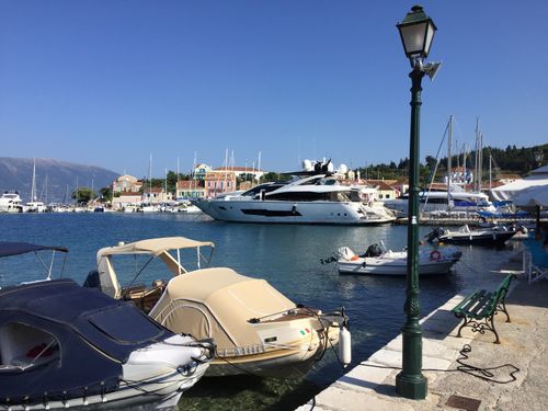 Free Picturesque yachts docked in the harbor of Fiskardo, Greece, under clear blue skies. Stock Photo
