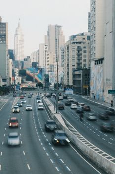 Blurred traffic on a bustling city street with skyscrapers in São Paulo, Brazil.