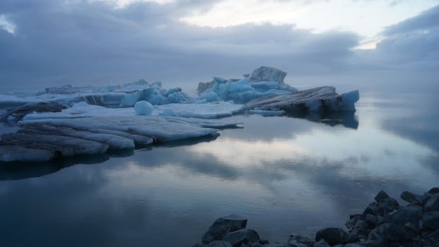 Tranquil scene of icebergs with reflections in calm waters, Iceland.