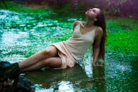 在斯里兰卡乌纳瓦图纳，一名妇女在雨天的草地上放松，呈现出一片宁静的场景