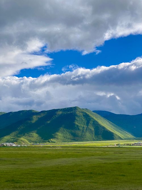 Free Beautiful lush green mountains beneath a dynamic cloudy sky, showcasing natural beauty. Stock Photo